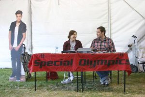 Hanging with Bieber: Senior Andi Ferraud-Shepher and junior Jonathon Christopher work the advanced public relations class booth during Conejo Valley Days to sell raffle tickets to benefit Ventura County Special Olympics. Photo by Will Mauton - Staff Photographer