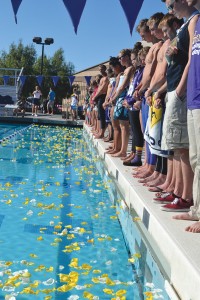 Never forgotten: Current and former members of the CLU swim and dive team placed yellow and white flower petals (above) in remembrance of Chrs Knorr, a former CLU swimmer who lost a battle with cancer in May 2013. All swimmers particpated in events after the ceremony (below). There will be a Chris Knorr Invitational taking place Jan. 3 and 4, 2014. Photos by Becky Pruett - Staff Photographer