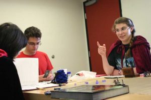 Planning for victory: Junior Mark Drach-Mienal and senior Katie Frank, along with their Dungeon Master, junior Josh Solberg,  gather every Friday to battle against mythical creatures and build their strengths in the popular role-playing board game, Dungeons and Dragons. Together, the students bring a little bit of magic to campus. Photos by Melina Esparza, Photo Editor