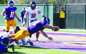 Leap of faith: Junior quarterback Nick Isham dives for a touchdown during the Kingsmen’s 41-17 win against the Sagehens. Isham garnered 316 total yards and was accountable for four touchdowns on the day. Photos by Isabella Del Mese - Photo Editor