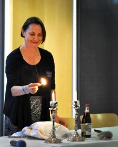 Rabbi Belle Michael lights candles before serving bread as part of the Yom Kippur tradition. Photo by Eric Duchanin.