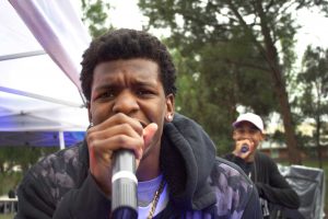 Tye Herod raps to the crowd at Callupalooza and delivers some much needed energy.  Rain didn’t stop the crowds from showing up to watch their fellow students perform.  Photo by Eric Duchanin - Senior Photographer