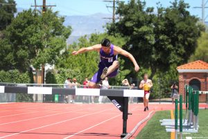 Senior team captain David Avila going over a barrier in the men’s 3000-meter steeplechase for Cal Lutheran. Despite facing an injury in the middle of the race, Avila finished the race. Photo by Madi Schmader - Staff Photographer