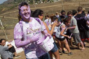 Paint the rocks, not each other: First-year Peer Advisor Austin Truong participates in the annual orientation paint fight at the “CLU” rocks. Photo by Brian Stethem