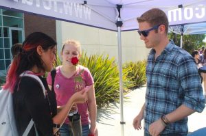 Caleb Solberg offers Lisa Hernandez a rose in honor of International Women’s Day.