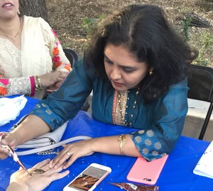 Embracing culture: Graduate student Rashi Jawalkar draws a henna tattoo on a student at the Diwali celebration. Photo by Dakota Allen- News Editor