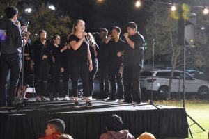 Fun and Games: Sophomore Nissa Rolf shares the stage with fellow aCLUpella members as they sing in front of friends, family and alumni at the homecoming carnival.  Photo by Aliyah Navarro - Photojournalist