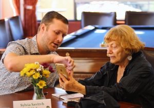 Tyler Berry teaches Sylvia Savith how to use different apps on her phone. Photo by Jacqueline Rodriguez - Photo Editor