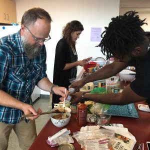 Sustainable eats: Former SEEd Garden director Samuel Thomas and senior J.B. Jean-Baptiste learn how to prepare meals that have sustainably-grown ingredients after author Florencia Ramirez’ demonstration. Photo provided by Garrett Mueller