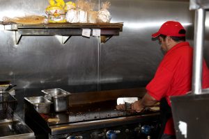 A chef at Establos Meat Market prepares food on the grill for one of their house-made Mexican dishes. Photo by Joc Smith, Photojournalist 