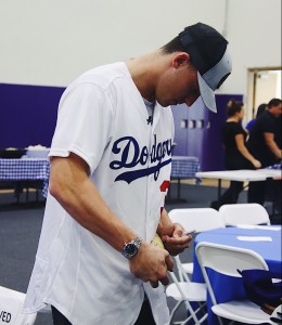 First baseman and outfielder Cody Bellinger signs a bat for the family of one of the victims of the Borderline shooting.  Photo by Arianna Macaluso - Photo Editor