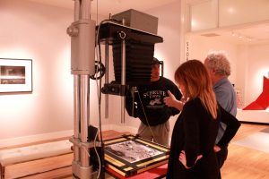 Guests at California Museum of Art Thousand Oaks stand around one of the original cameras Ansel Adams used. Photo by Joc Smith- Photojournalist. 