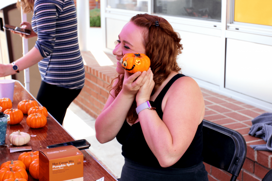 Melissa Tobey, junior, poses with her decorated pumpkin on the Spine on Tuesday Oct. 15.