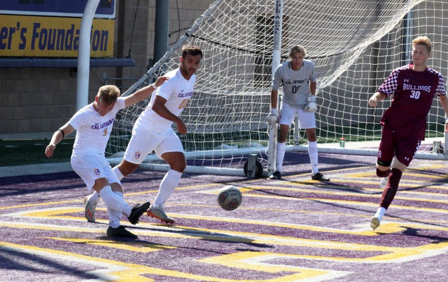 First-year forward Matt Myers (left) and junior defender Lucca Rodrigues (middle) work to kick the ball out of the defensive zone, assisting sophomore goalkeeper Owen Ebner (right).
