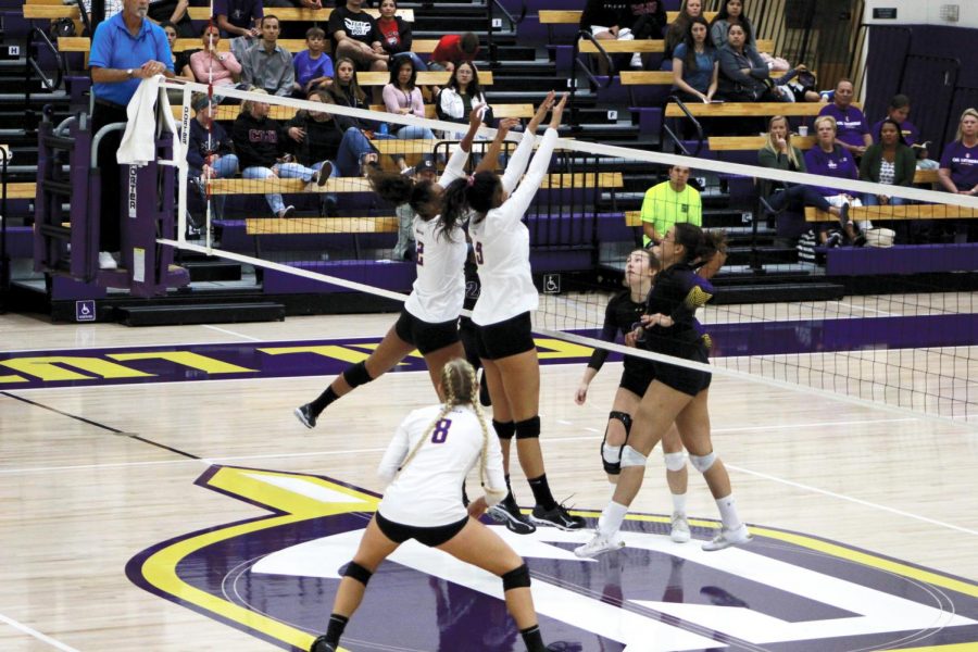 Junior outside hitter Sarah Hein (left) and first-year middle blocker Christina Williams (right) try to block the ball from the Whittier Poets on Oct. 5.