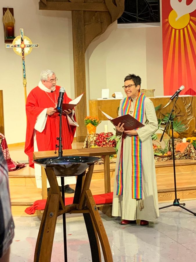 Associate professor Colleen Windham-Hughes smiles at the crowd as Bishop Guy Erwin reads the communion text on Friday Oct. 25.