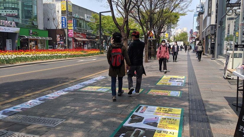 People can be seen walking on the sidewalks in downtown Daegu, South Korea, a hotspot in the global COVID-19 pandemic.
