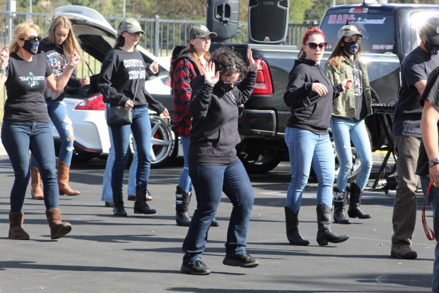 Community members start an impromptu line dance during the Borderline Remembrance Drive.