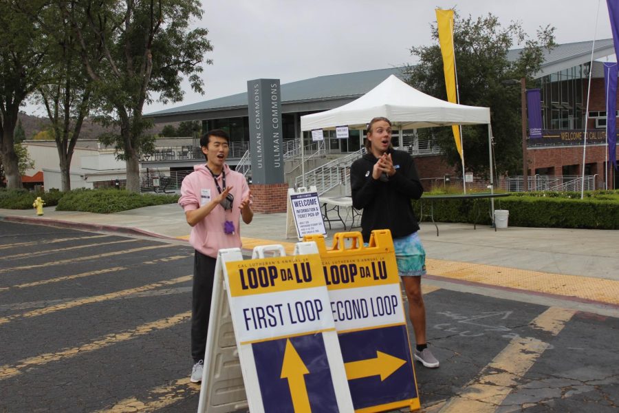 Freshmen Andrew Choi (left) and Sophomore Ryker Linn (right) cheer on the runners as they get ready to cross that finish line or knock out their final loop.