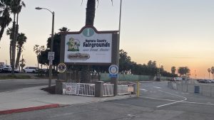 Signage reads Ventura County Fairgounds and shows a sunset in the background of the fairgounds parking lot
