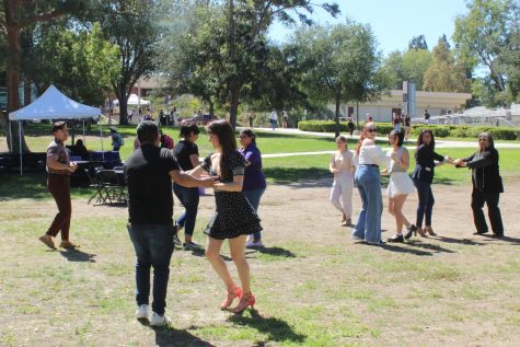 Casa Cha Cha dance instructors teaching CLU staff and students the fundamentals of salsa dancing in Kingsmen Park. 