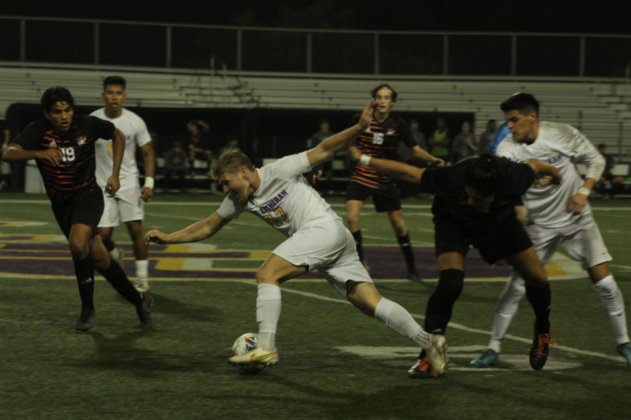 Kingsmen forward Matt Myers dribbles through the Occidental Tigers midfield with the ball.