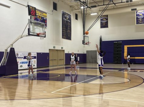 Two members of the Cal Lutheran womens basketball team watch as Isabella Flores takes a free throw in a practice session inside Gilbert Arena.