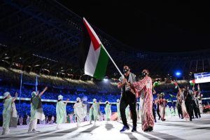 Dania Nour bears the flag of Palestine alongside weightlifter and teammate at the opening ceremony of the 2020 Olympic Games in Tokyo.