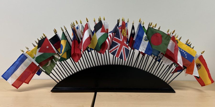 Aqui hay banderas chiquitas de todo el mundo colocadas en un semi circulo
