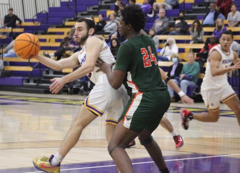 Cal Lutheran basketball player makes a pass as University of La Verne player guards him.