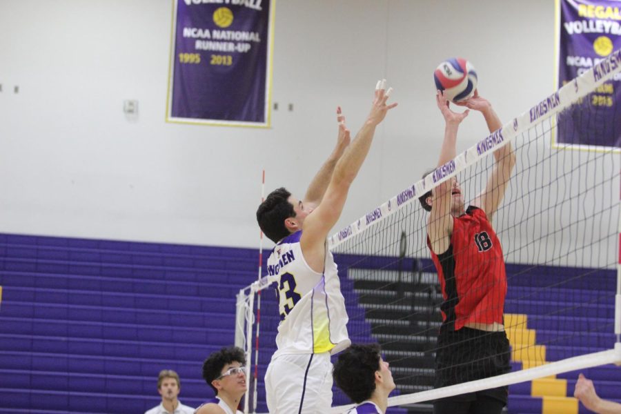 A member of the Kingsmen volleyball team attempts to block a hit from North Central University player.