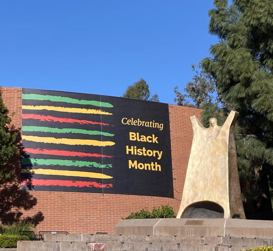 A+Black+History+Month+banner+acts+as+a+bold+backdrop+to+the+Gumby+statue+by+Cal+Lutheran%E2%80%99s+Pearson+Library.+%E2%80%9CBlack+History+Month%E2%80%A6+is+calling+us+to+something+greater+than+the+optics+of+black+history%2C%E2%80%9D+Rev.+Scott+said+at+the+first+weekly+Black+History+Month+Chapel+Worship+Service+on+Feb.+2+at+Samuelson+Chapel.
