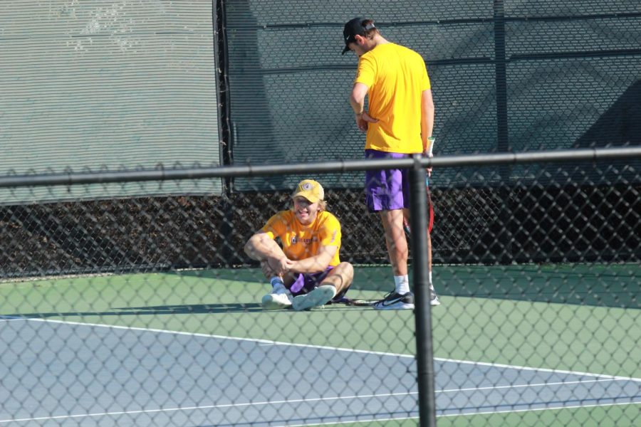 A+member+of+the+Kingsmen+tennis+team+lays+on+the+ground+in+pain+as+his+teammate+looks+over+him.