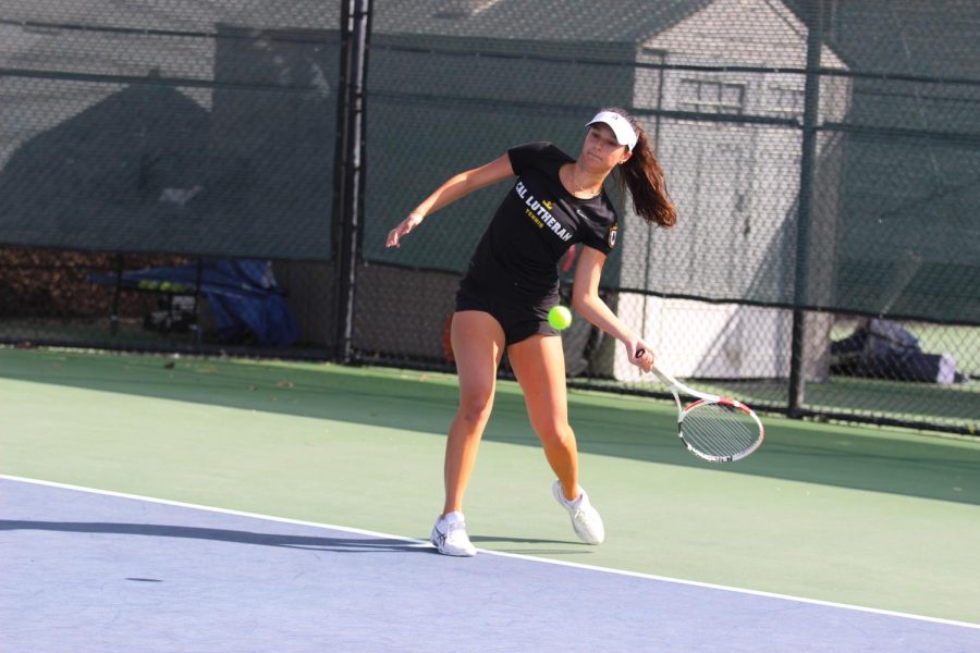 A member of the Regals tennis team hits a forehand.