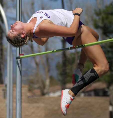 A member of the Regals track and field team jumps over the pole.