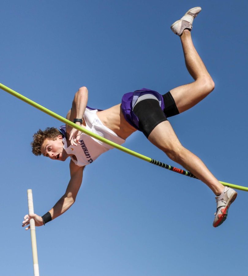 A member of the Kingsmen track and field team jumps over the pole.