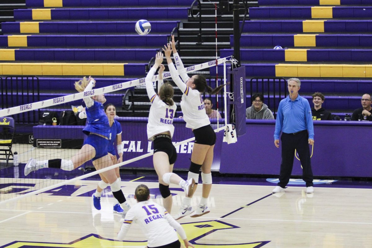 Kira Mortensen and Sophia Muller blocking the ball. 