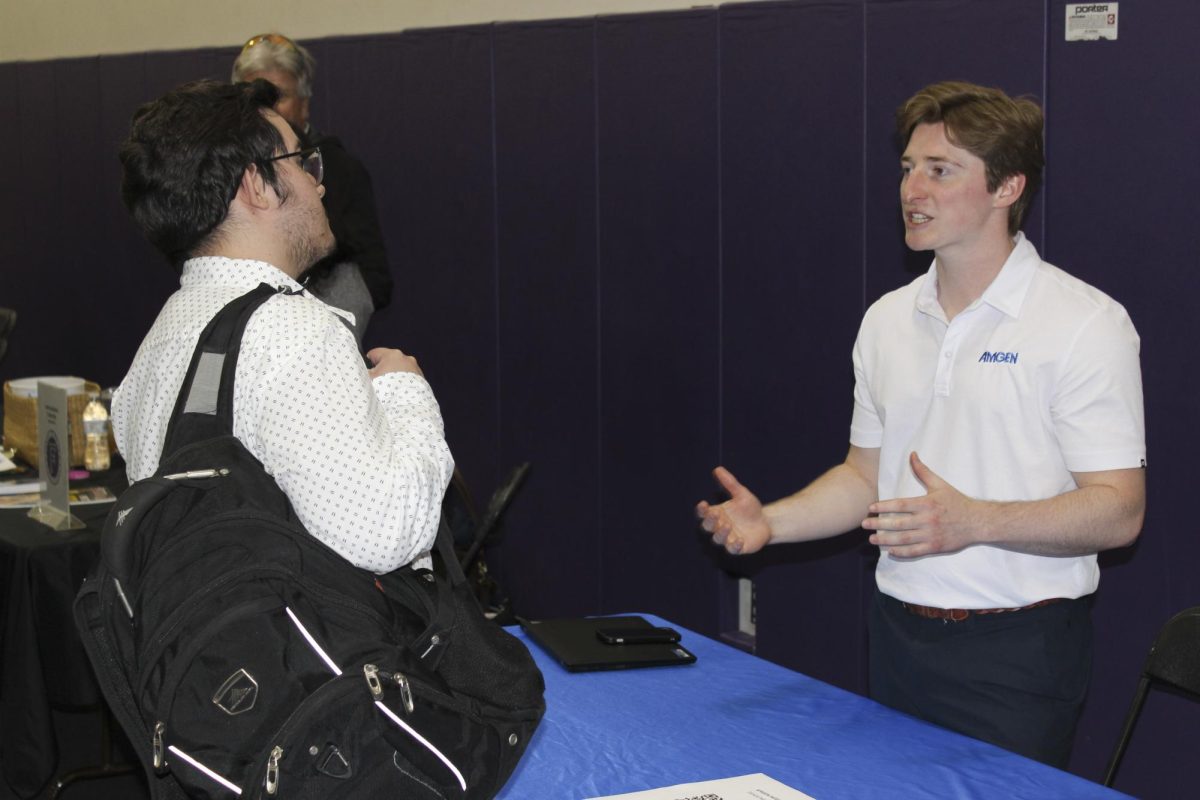 A student listens to a pitch about Amgen.