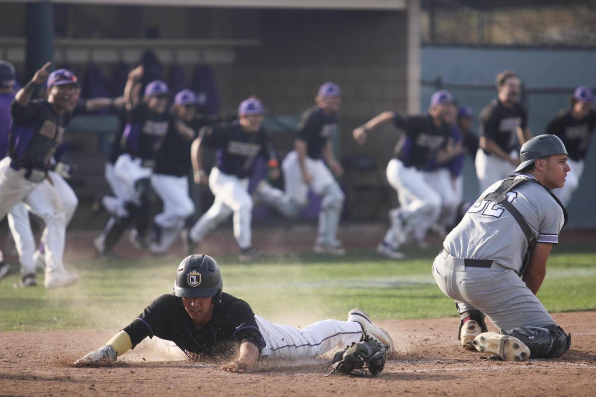 Junior Philip Jeong, representing the winning run batted in by sophomore Jacob Blickenderfer, slides headfirst into home as teammates celebrate behind him.